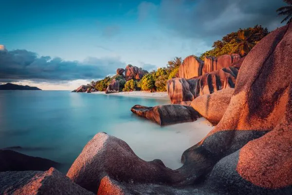 Unique shaped granite boulders and a dramatic sunset at Anse Source d'Argent beach, La Digue island, Seychelles. Long Exposure