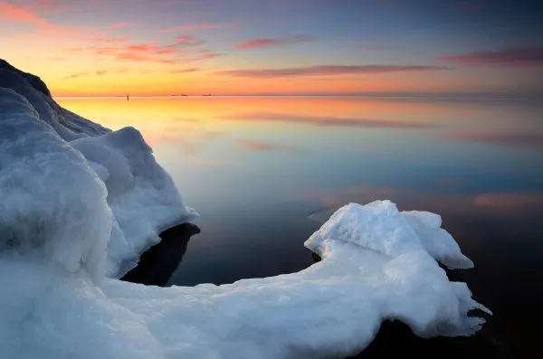Baltic sea shore in snowy winter at the sunset