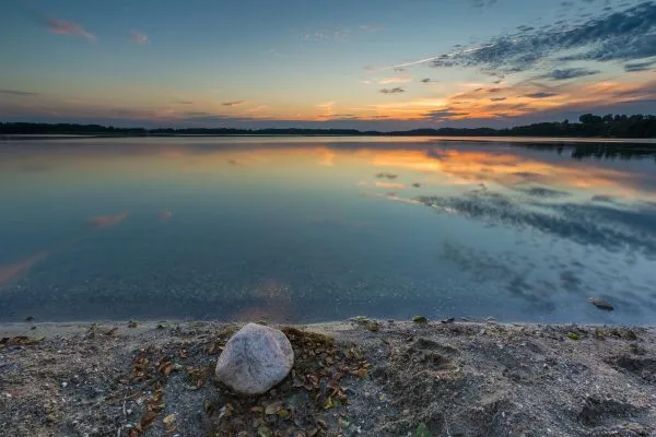 Beautiful lake at sunset landscape with cloudy sky reflecting in water