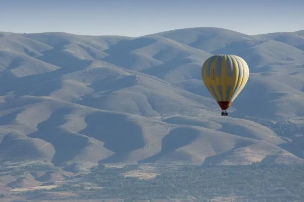 hot-air-balloon-over-a-rocky-landscape-SBI-300935592